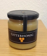 Ein Glas Gitterhonig mit schwarzem Etikett