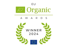 Das Bild zeigt das Logo der EU Organic Awards 2024. Oben ist ein Blatt-Symbol mit Eu Organic, darunter steht AWARDS. In einem grünen Blattkranz steht Winners, mit einer EU-Flagge am unteren Rand. 