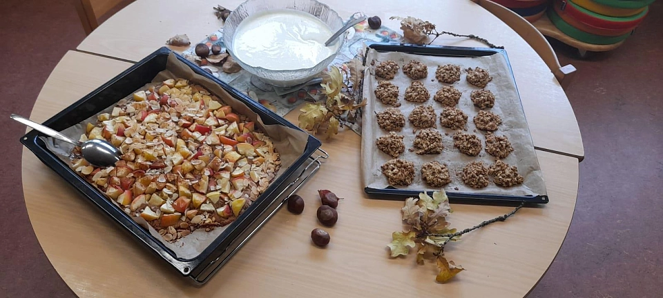 Ern&auml;hrungstage: Das Bild zeigt Selbstgebackenes und eine Sch&uuml;ssel mit Joghurt auf einem mit Kastanien und Herbstlaub dekorierten Tisch.