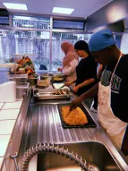 Dieses Foto zeigt drei Jugendliche, die in einer Küche gemeinsam Speisen zubereiten. 
˜ Bildnachweis: Saher Khanaqa-Kükelhahn