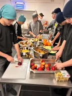 Das Foto zeigt eine Gruppe von Jugendlichen, die gemeinsam in einer Küche Obst schneiden. 
˜ Bildnachweis: Saher Khanaqa-Kükelhahn